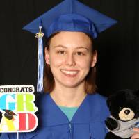 person holding graduate prop and stuffed bear
